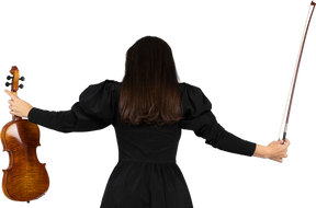 Rückansicht einer geigenspielerin im schwarzen kleid mit ausgebreiteten händen