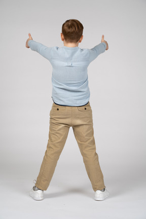 Rear view of a boy showing thumbs up