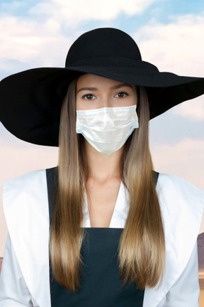 Femme portant un chapeau et un masque facial