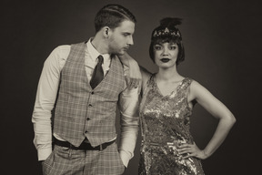 Well-dressed retro-styled couple posing in the dark