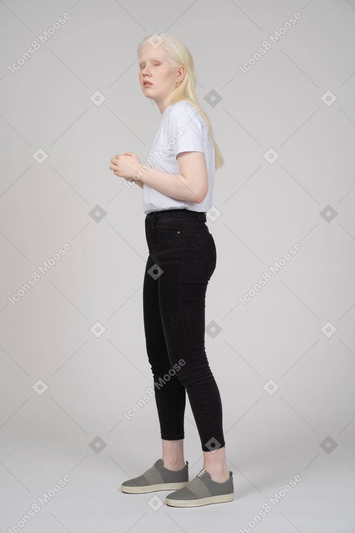 Vista lateral de una mujer joven con ropa informal mirando por encima del hombro
