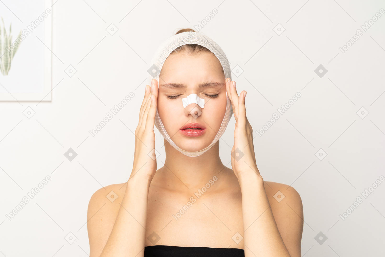 Young woman with bandaged head touching her temples