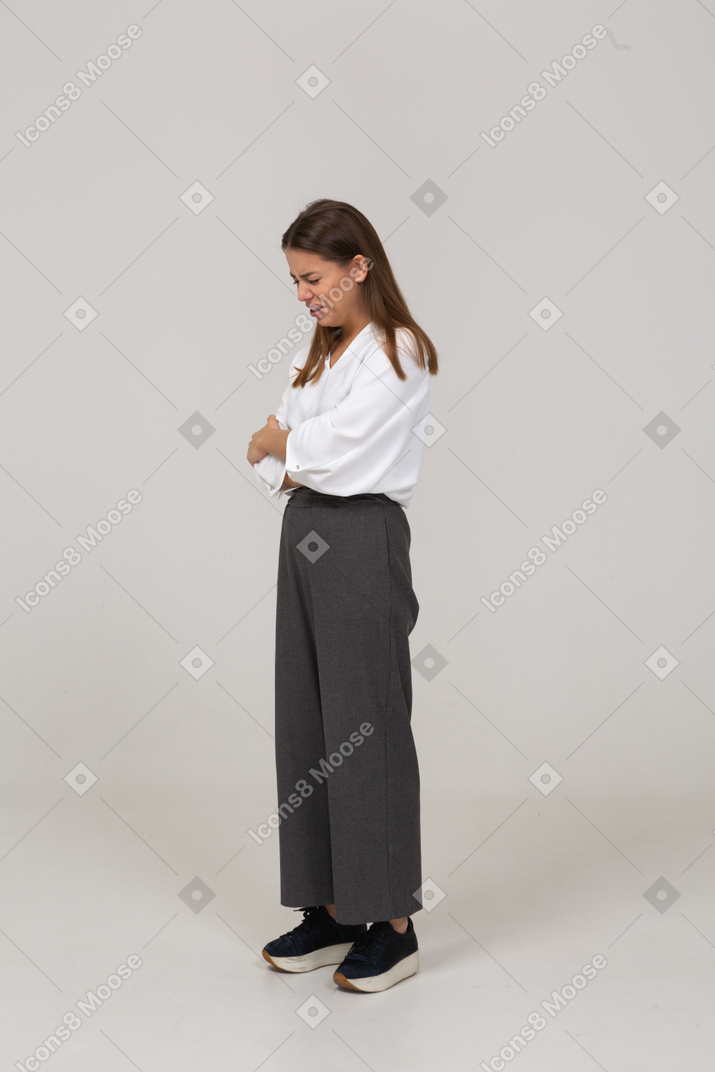 Three-quarter view of a crying young lady in office clothing crossing arms