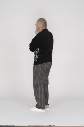 Back view of old man standing with crossed arms
