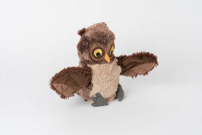 A cute brown plush owl sitting isolated against a plain white background