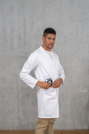 Médecin de sexe masculin mettant son stéthoscope dans sa poche