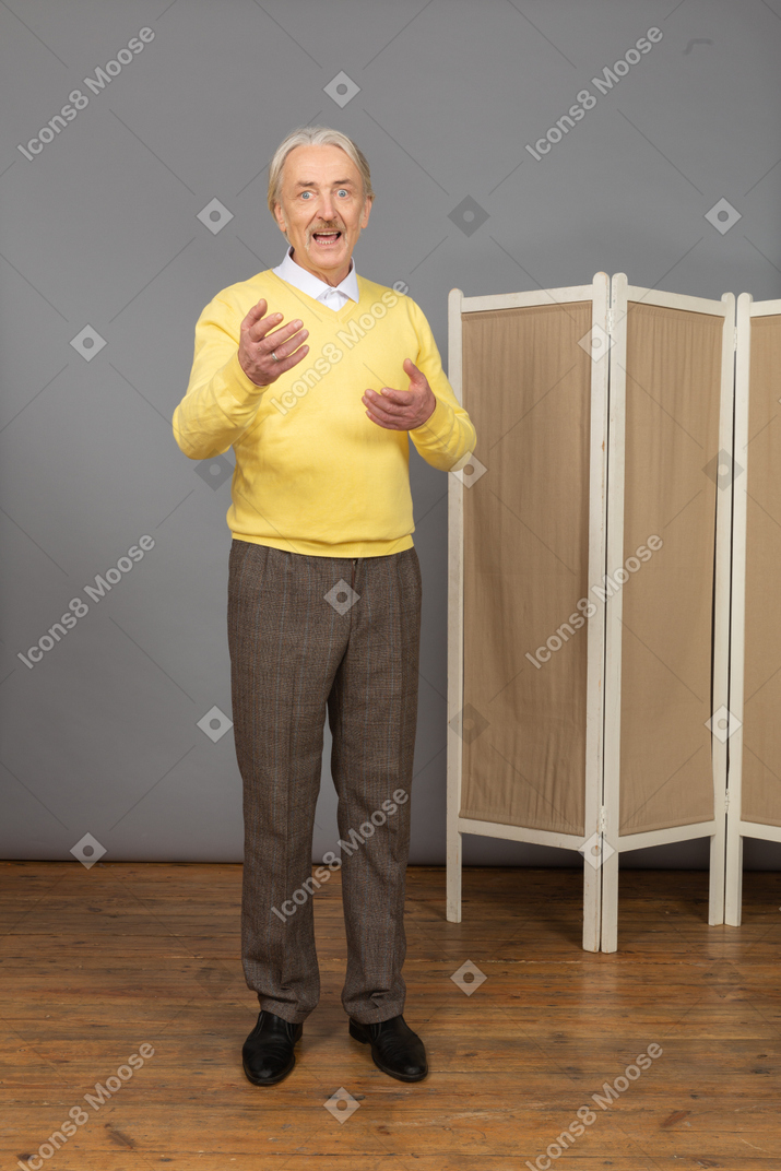 Front view of an old man explaining something while gesticulating
