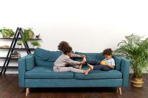 Good looking boy and girl play on the sofa