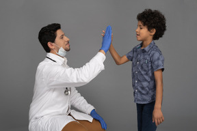 Doctor giving high five to a boy
