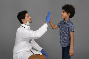 Docteur donnant high five à un garçon