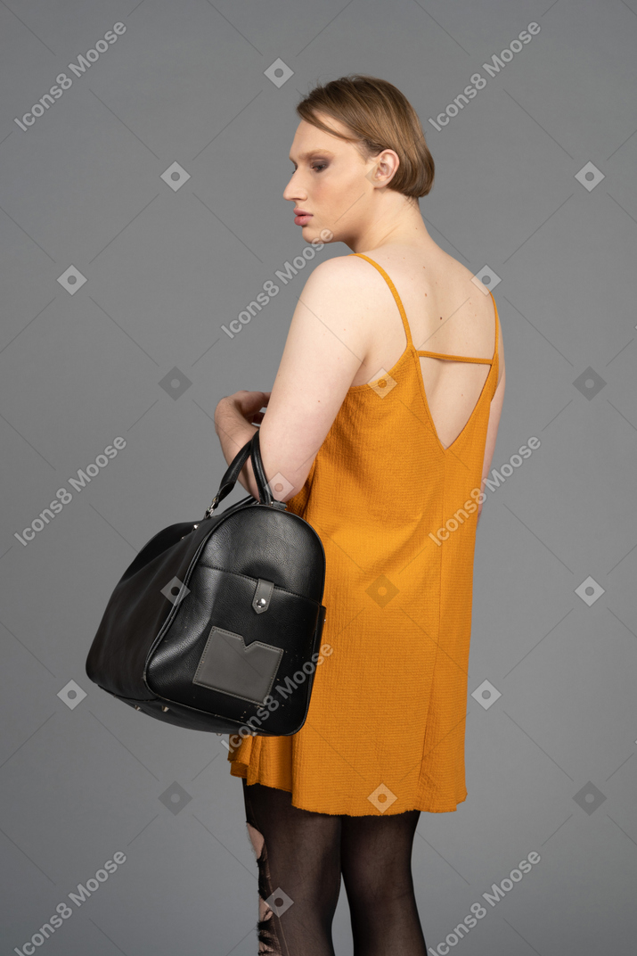 Vista traseira de um jovem queer carregando uma bolsa