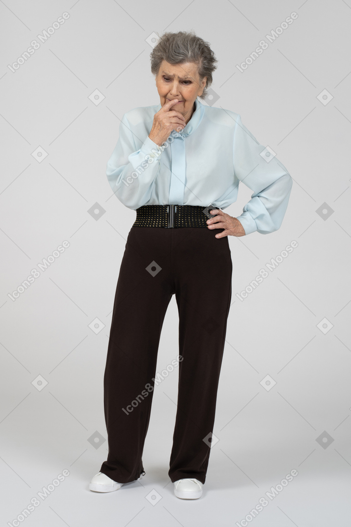 Vista frontal de una anciana tocando la barbilla con incertidumbre
