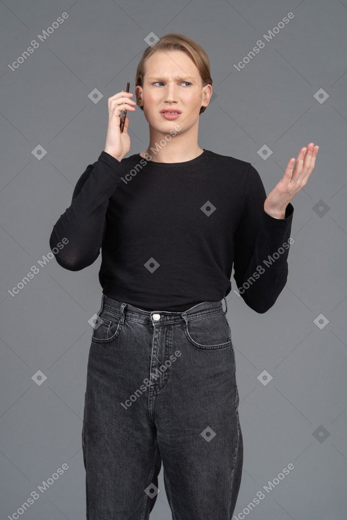 Растерянный человек жестикулирует во время разговора по телефону