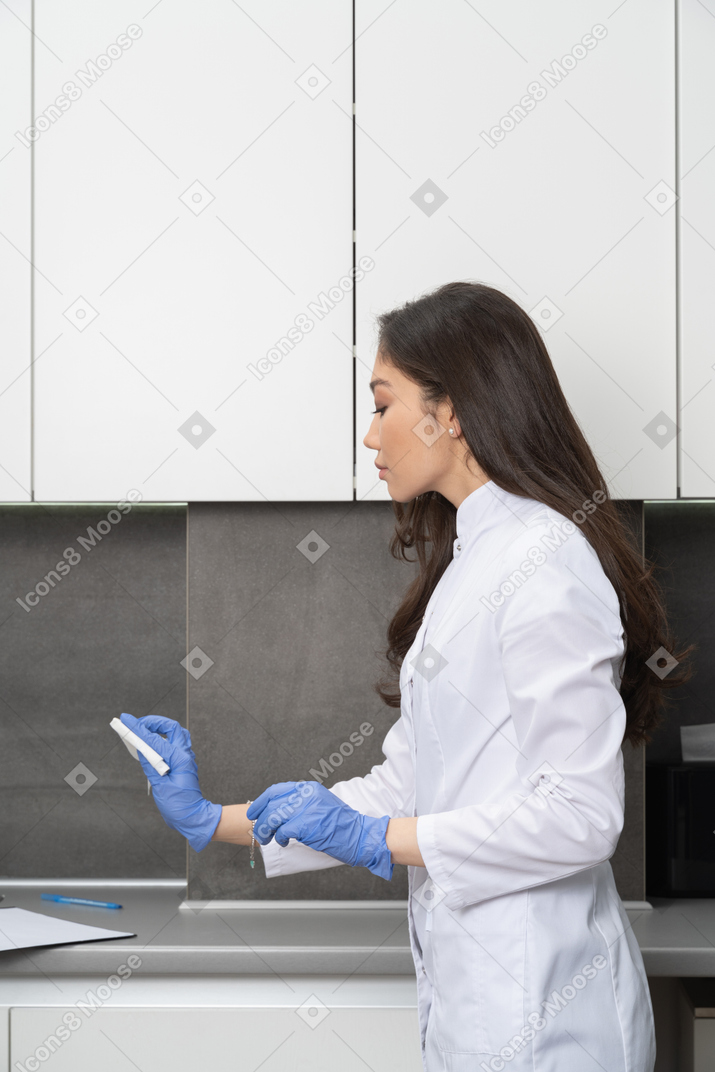Side view of a female doctor cleaning her medical cabinet