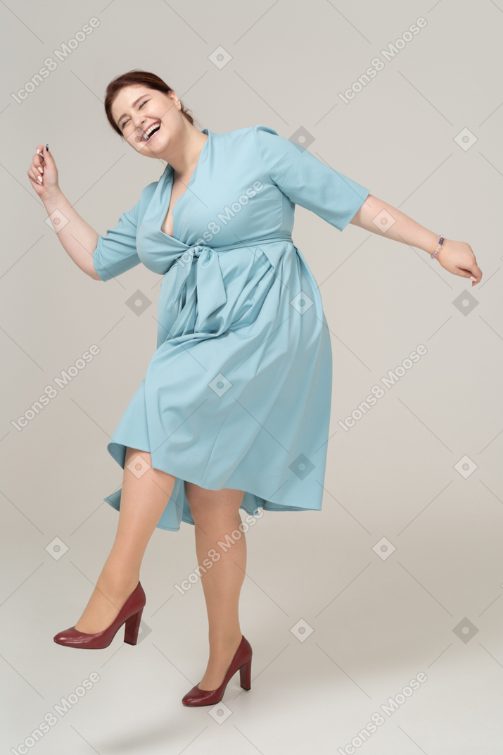 파란 드레스를 입고 포즈를 취하는 행복한 여자의 전면 모습