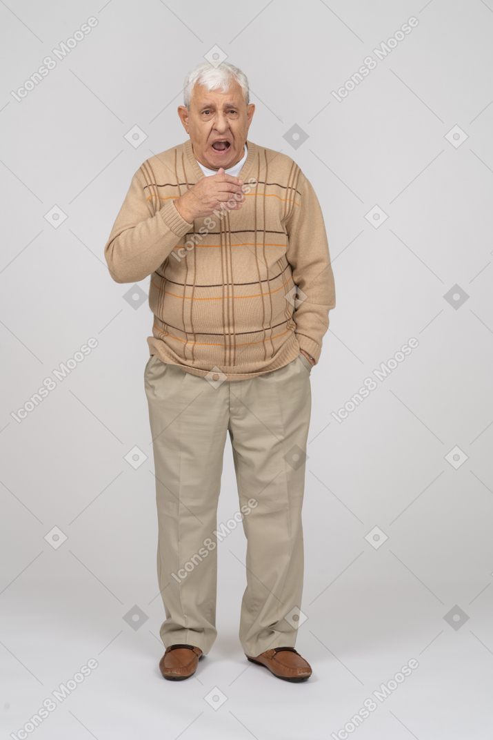 あくびをしているカジュアルな服を着た老人の正面図