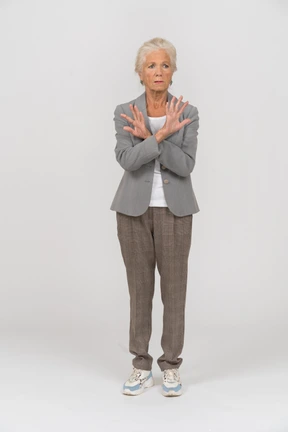 Front view of an old lady in suit showing stop sign
