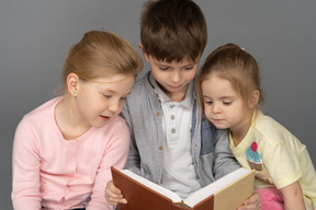 Tre adorabili bambini che leggono baldoria