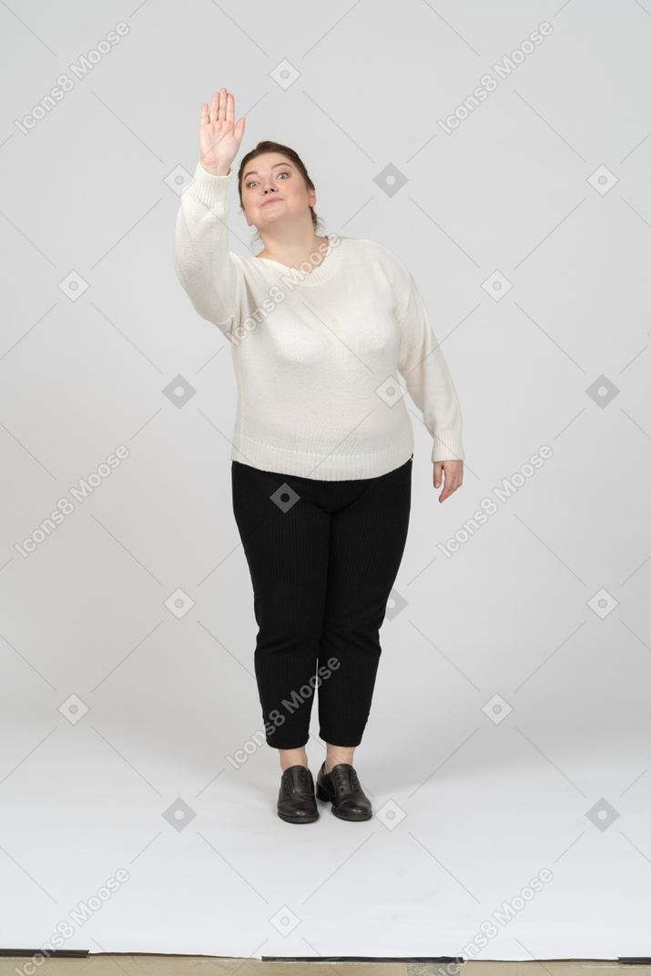Vista frontal de uma mulher plus size em roupas casuais cumprimentando alguém