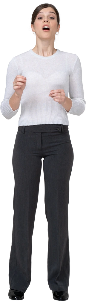 Front view of a sneezing young woman in office clothing
