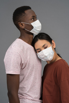 A young couple wearing face masks