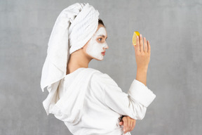 Back view of a woman in bathrobe with a lemon in hand