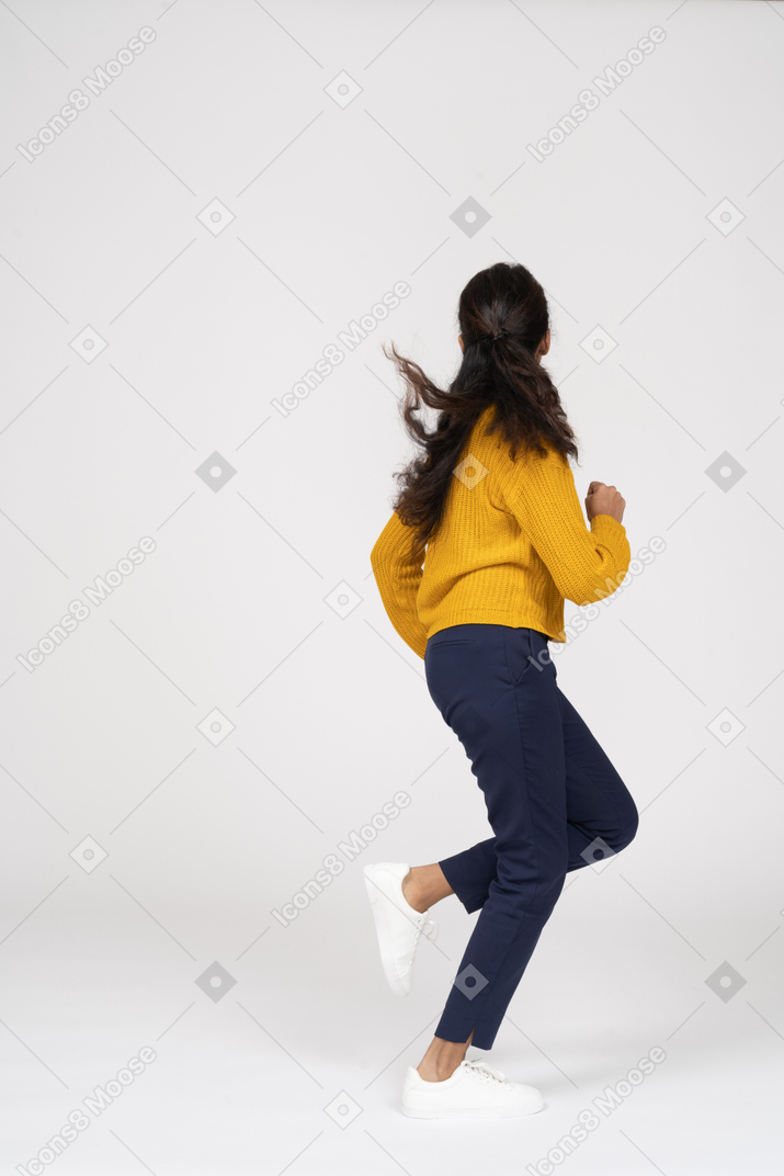 Vista laterale di una ragazza in abiti casual che corre