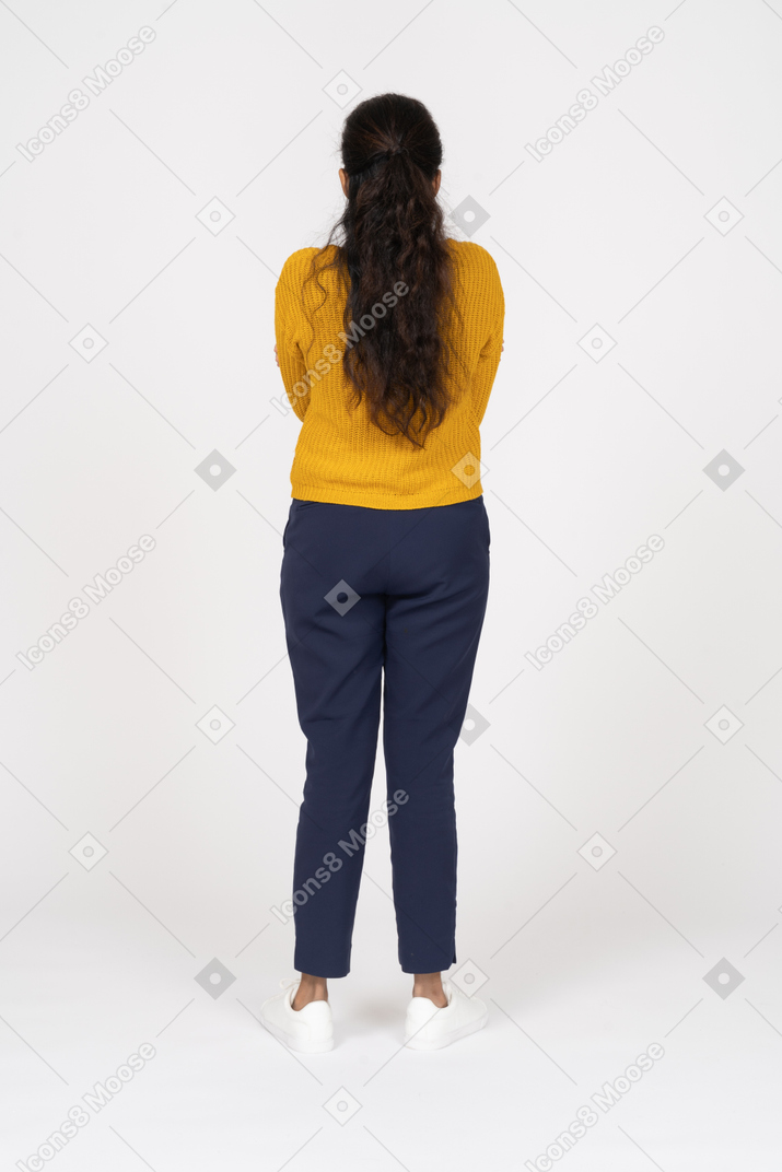 一个穿着休闲服的女孩交叉双臂站立的后视图