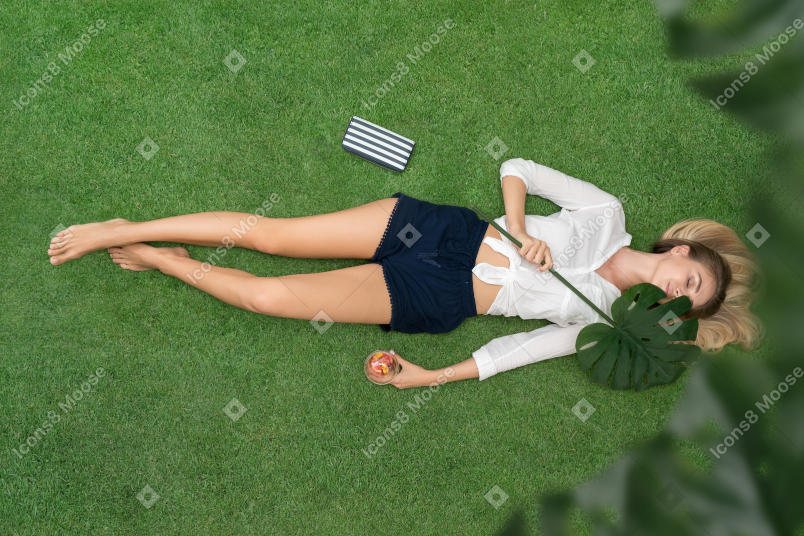 Attractive young woman lying on her back on the grass