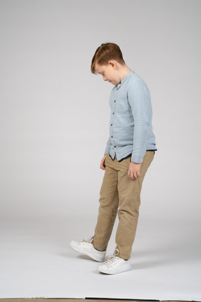 Boy standing and looking down
