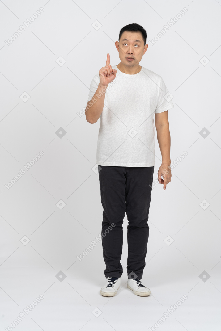 Front view of a man in casual clothes pointing up