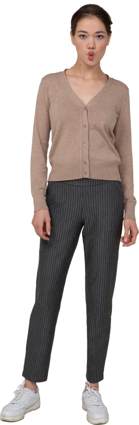 Front view of a pouting lady in pullover and pants looking at camera