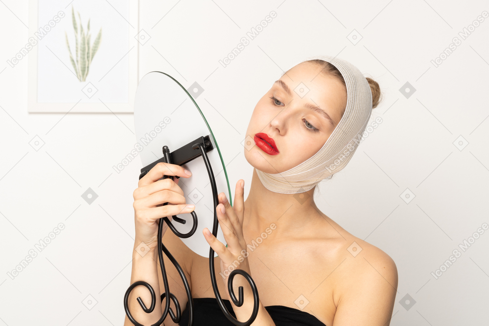 Young woman with head bandage holding a mirror