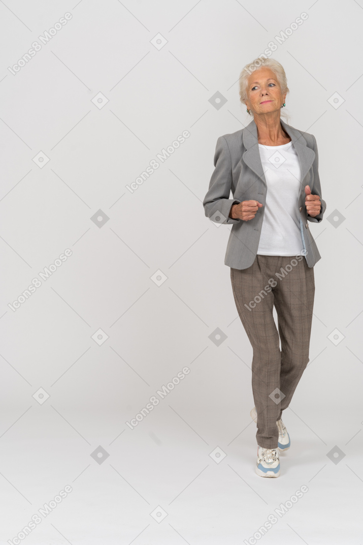 Front view of an old lady in suit running forward