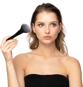 Vue de face d'une jeune femme sensuelle réfléchie tenant un pinceau de maquillage