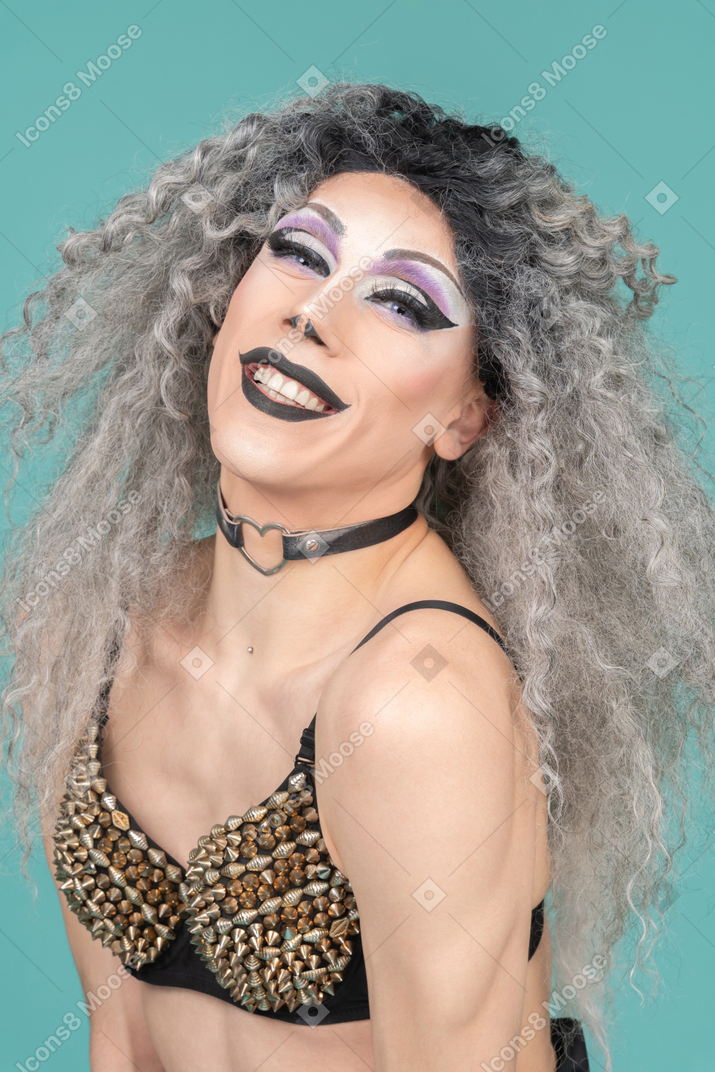 Retrato de uma drag queen em sutiã cravejado sorrindo