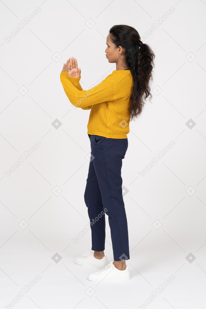 Vista lateral de uma garota com roupas casuais mostrando um gesto de pare