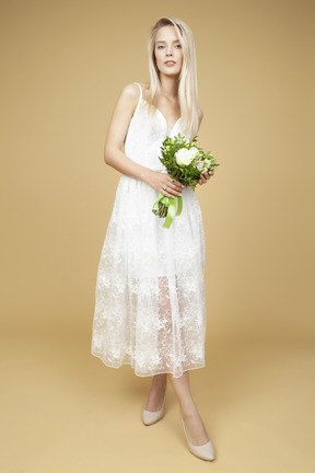 Bride holding wedding bouquet and posing  for a picture