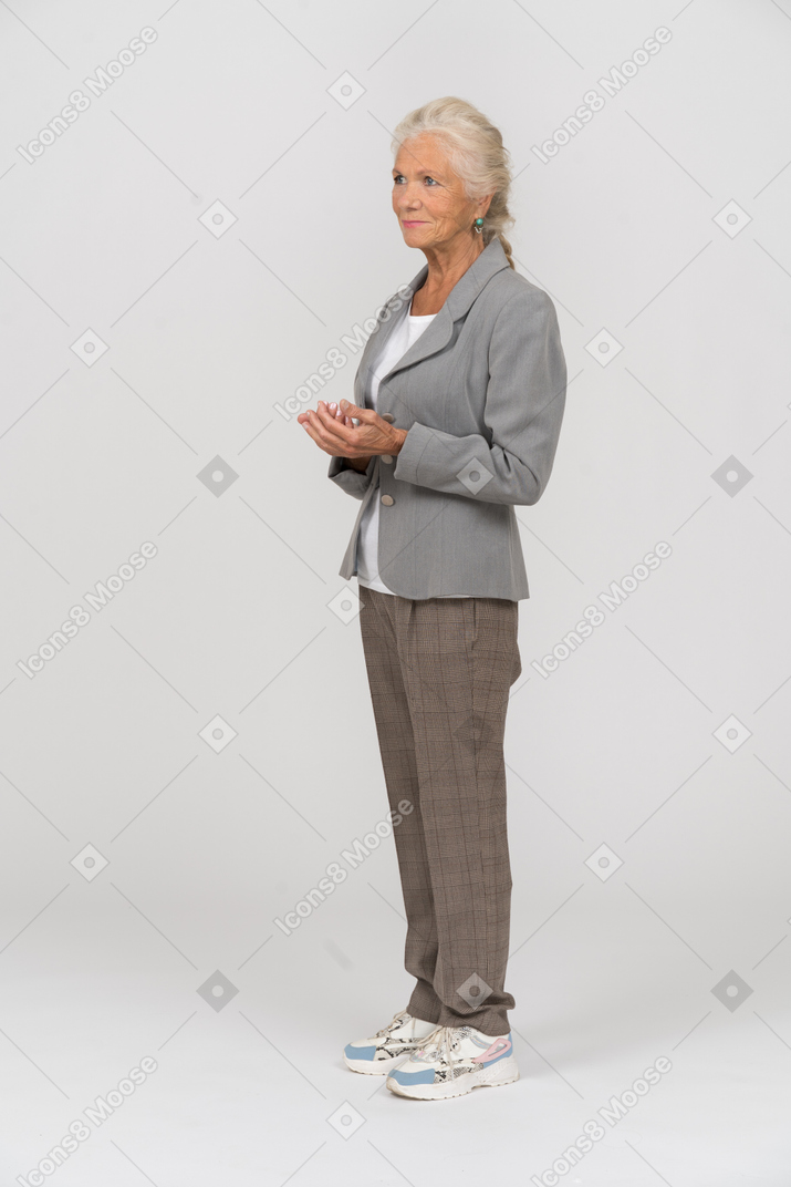 Senhora idosa de terno em pé de perfil