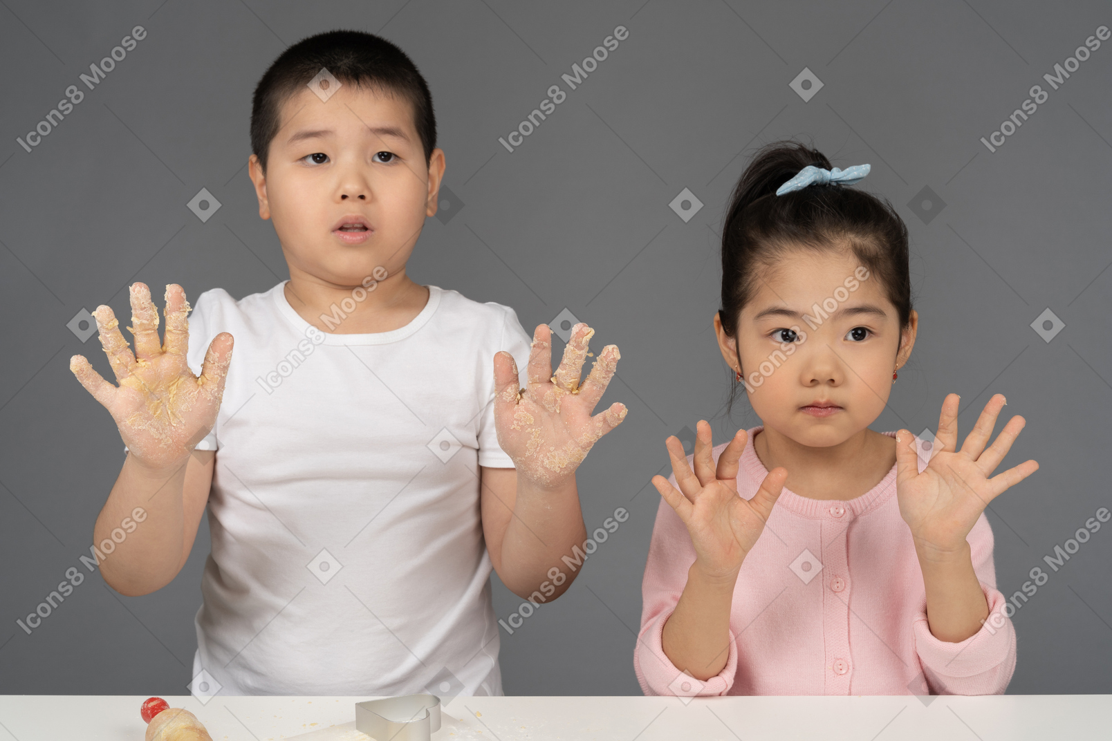 Brother and sister posing with their hands up