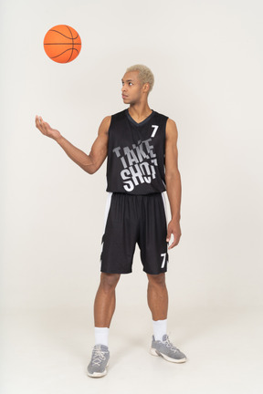 Front view of a young male basketball player throwing a ball