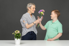 Mutter und sohn machen blumenstrauß