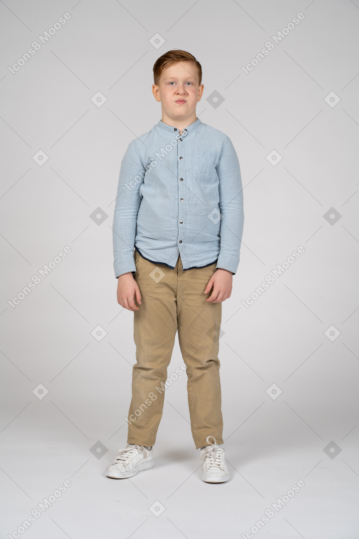 Front view of a cute boy making faces and looking at camera