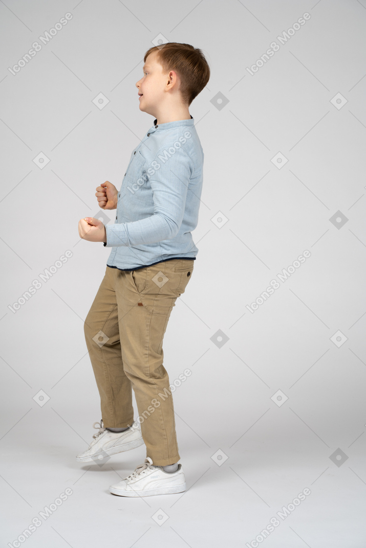 一个可爱男孩单腿平衡的侧视图