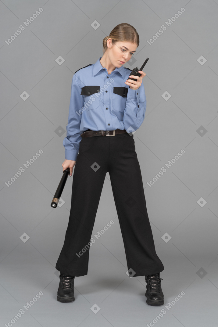 Guardia de seguridad femenina con bastón y radio