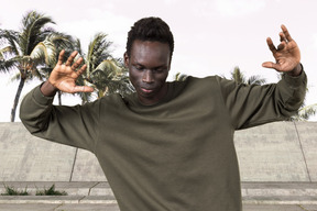 A man in a green shirt holding his hands up