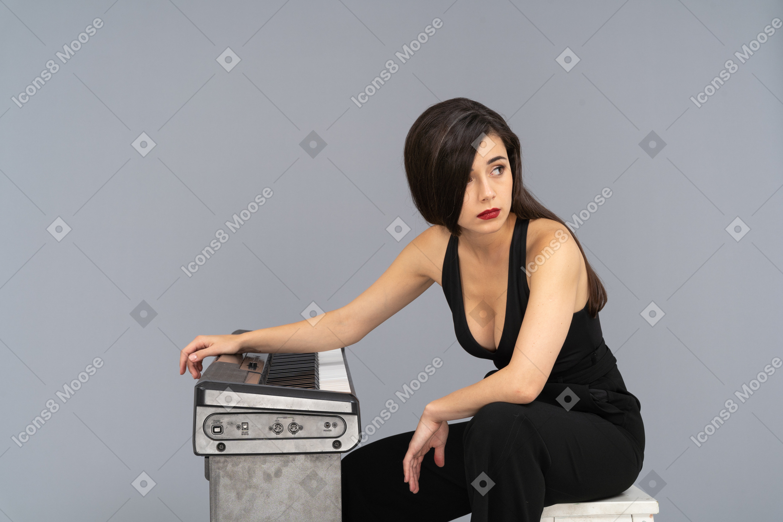 Side view of a tired young female sitting by the piano