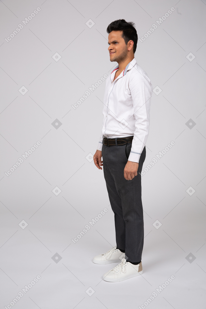 A frowning man standing in office clothes