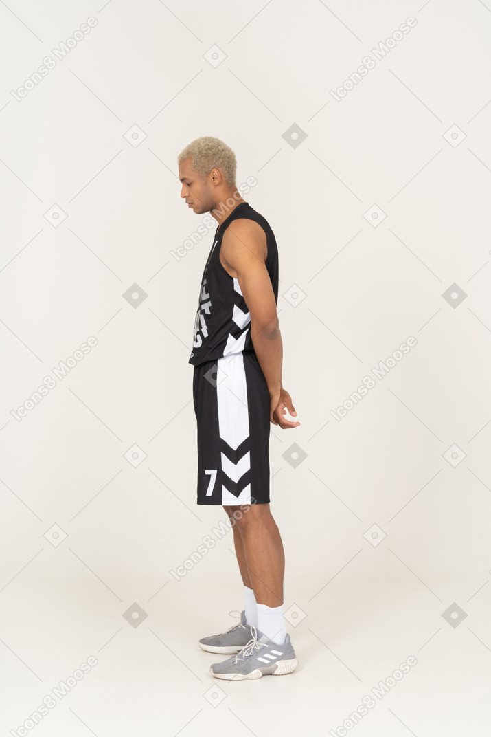 Vista laterale di un giovane giocatore di basket maschile ritirato