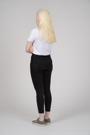 Rear view of a young blonde girl with folded arms